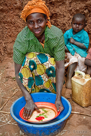 Woman Washing Plate in blue tub