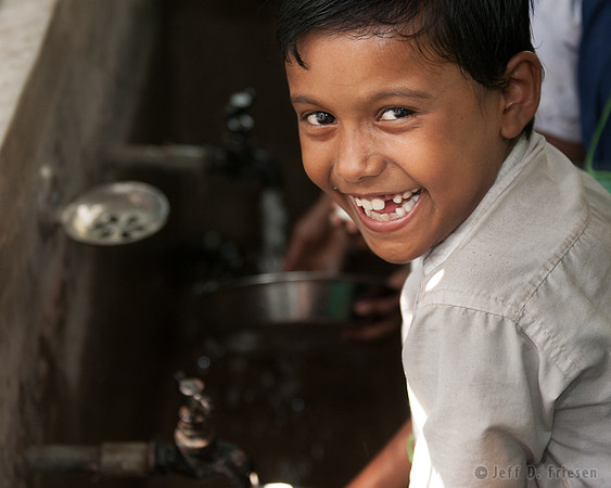 Boy laughing at sink