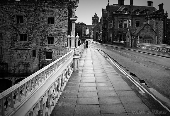 Man on bridge sidewalk BW