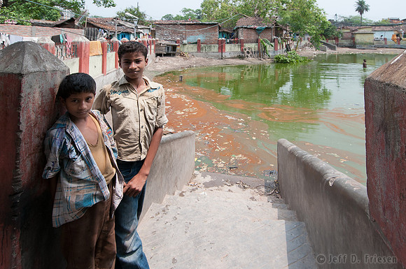 Two boys at polluted pond
